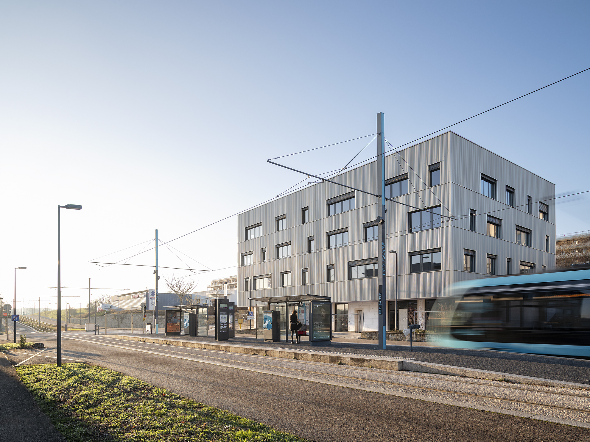 Tramway qui passe devant un immeuble.